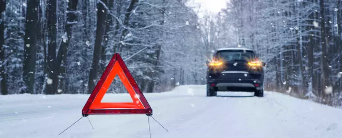 Warning triangle by car in snow