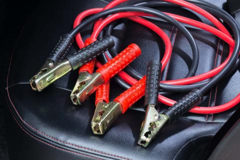 Decent jump leads should have both length and girth. A thicker cable can transfer more electrical current, giving your dead battery a better boost. This is especially important if your car has a large engine or is equipped with engine start-stop technology, because both require a heavy-duty battery. The packaging will say what size engine the leads are suitable for. It's better to buy thicker leads, even if you have a car with a small engine, because you may change it for a larger car at some point or you may want to loan your leads to a stranded neighbour or stranger who needs to jump-start their own vehicles. As for length, 3 metres/10 feet is fine if both cars are parked close to each other, but 5-metre cables or longer could be useful if you’re stranded in a tight spot. However, the longer the cable, the thicker it’ll need to be in order to transfer the same current Red and black jump leads on car seat